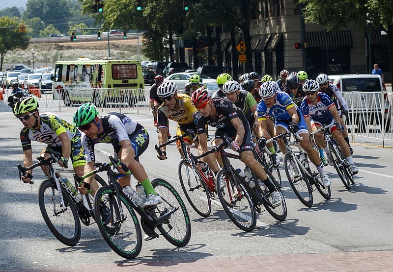 Cyclists round a turn from Martin Luther King, Jr., Boulevard to Market Street as they compete in the men's Masters 35+/45+ category of the Goss Insurance Criterium race on Saturday, Aug. 27, 2016, in Chattanooga, Tenn. The criterium race, part of the larger River Gorge Omnium event, consisted of multiple categories of races in a route that circled the TVA and EPB buildings in downtown Chattanooga.