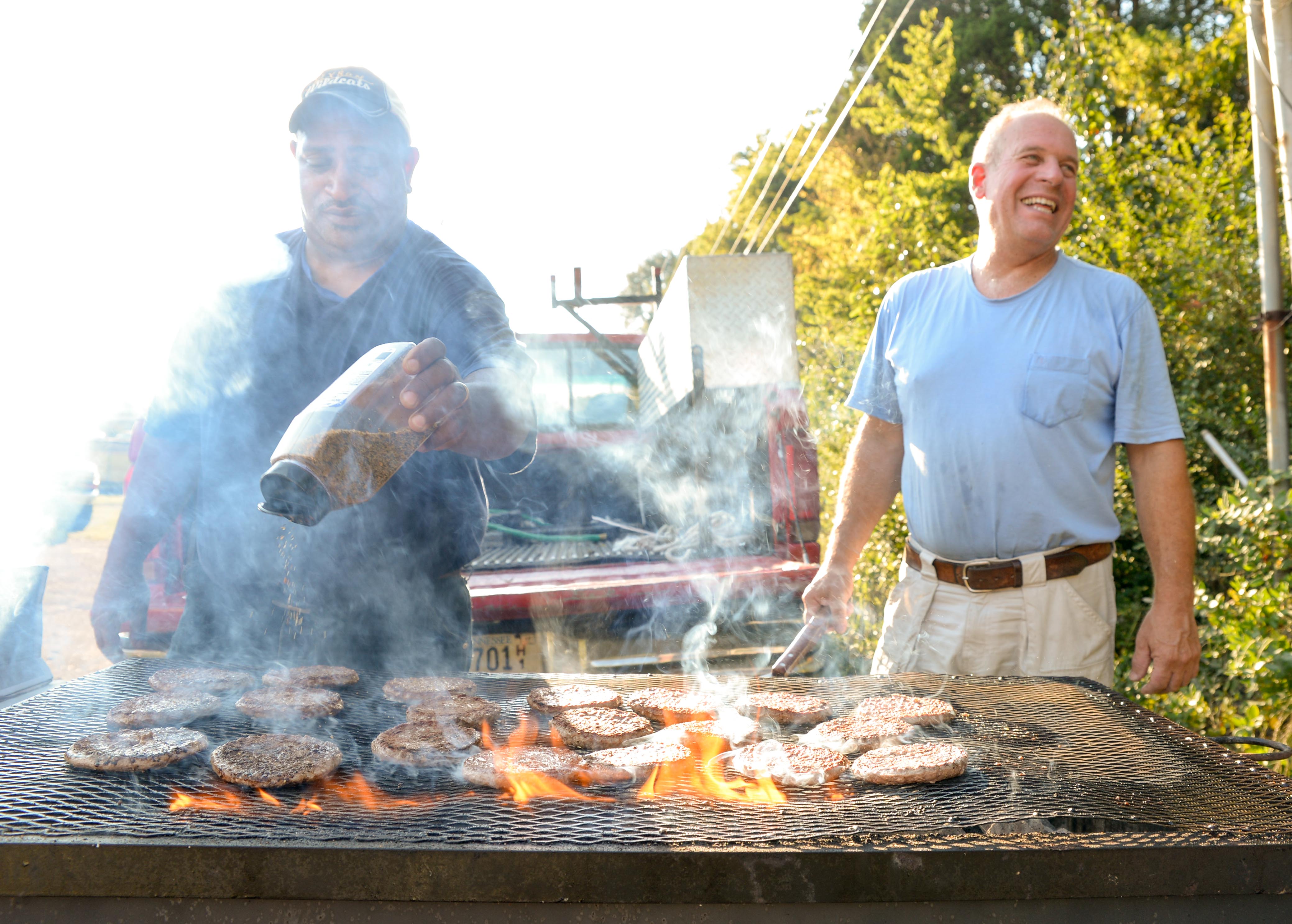 (Photo by Mark Gilliland) Sean Hill (left) and Klaus Beyer grill hamburgers before the game at Hixson High School. Hixson faced Meigs County on August 25, 2017.