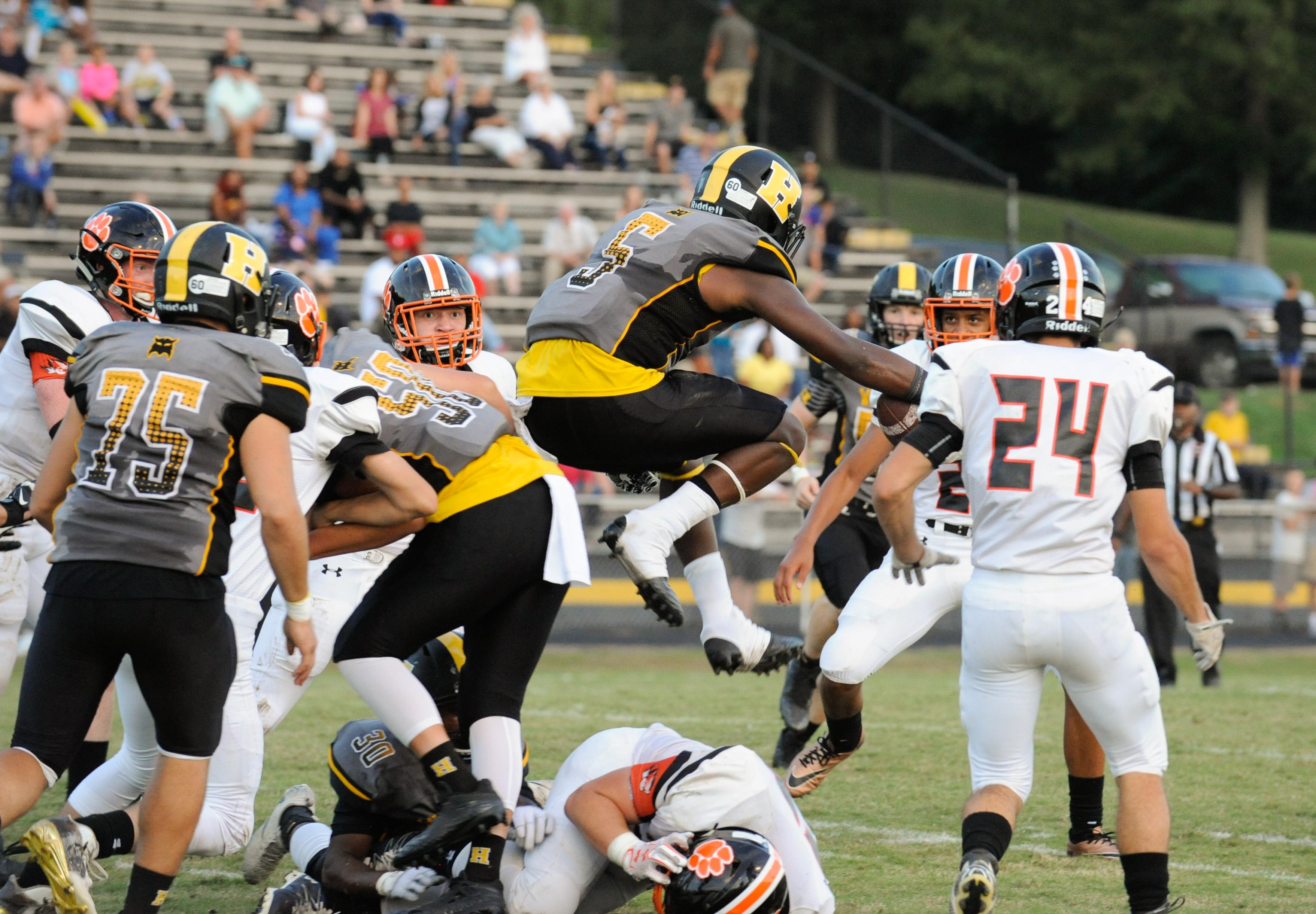 (Photo by Mark Gilliland) Hixson's Latrell Sandefer jumps over Meigs County's Luake Hair during the game on August 25, 2017.
