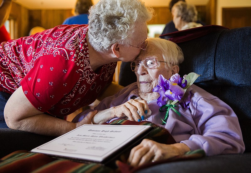 Iris Weatherwax, 97, receives a kiss from her daughter, Beverly Weatherwax, 70, of Flint, after belatedly being awarded her high school diploma in a private ceremony on Wednesday, Aug. 23, 2017, at her residence in Grand Blanc. Weatherwax was barred from graduating from the Davison Community School District in 1938 because she was pregnant at the time, despite the fact that she was also married. Before Wednesday's ceremony, Weatherwax asked, "Is it alright if I cry?" (Terray Sylvester/The Flint Journal-MLive.com via AP)

