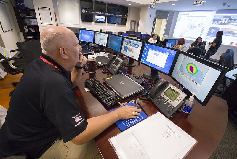 Michael Lambert, the emergency operations center controller at the Galveston County Office of Emergency Management, looks at a bank of monitors in center in Dickinson, Texas, Thursday, Aug. 24, 2017. (Stuart Villanueva/The Galveston County Daily News via AP)