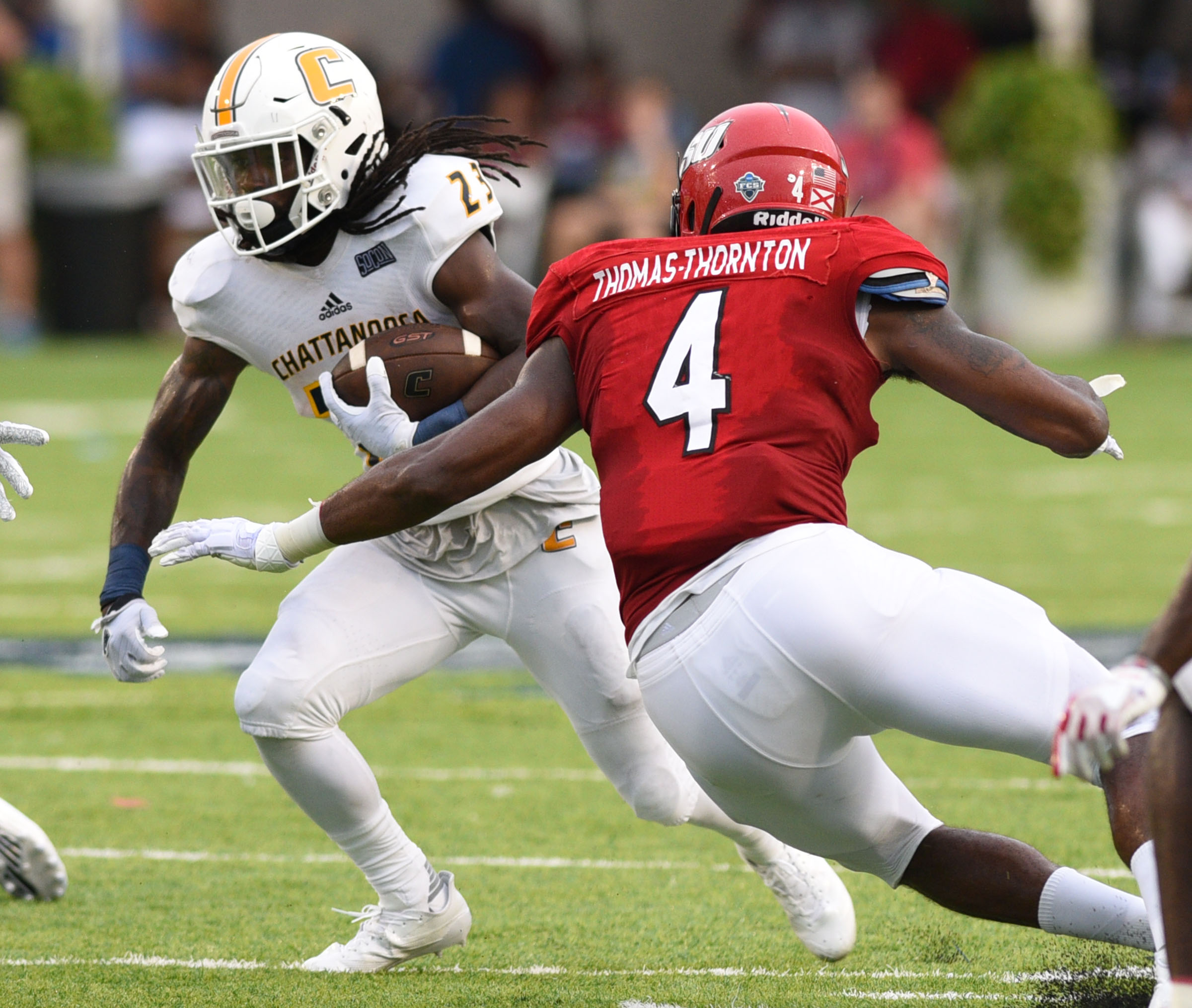 UTC's Richardre Bagley (23) gets past Jacksonville's Justin Thomas-Thornton (4). Defending is Jacksonville's Ra'Shad Green (8). The University of Chattanooga Mocs met the Jacksonville State Gamecocks in the Guardian Credit Union FCS Kickoff at the Carmton Bowl in Montgomery, Alabama on August 26, 2017.