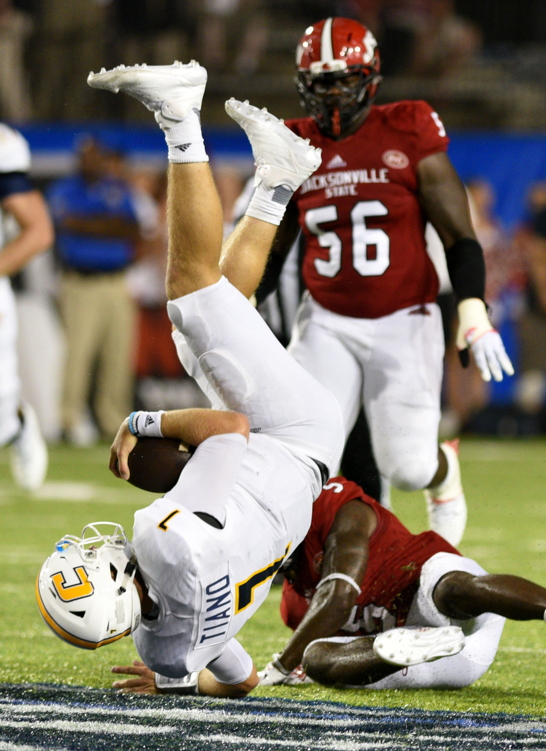UTC quarterback Nick Tiano (7) is upended after a first down run by Jacksonsville's Siran Neal (5). The University of Chattanooga Mocs met the Jacksonville State Gamecocks in the Guardian Credit Union FCS Kickoff at the Carmton Bowl in Montgomery, Alabama on August 26, 2017.