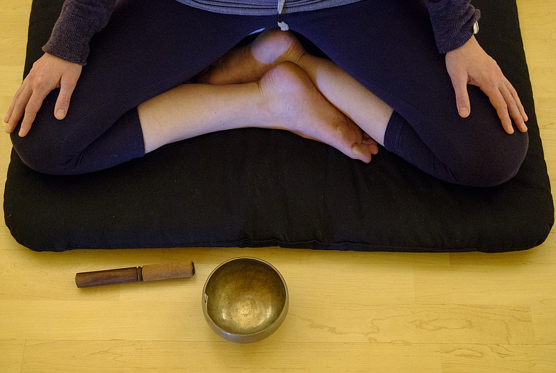 A singing bowl sits in front of her as Janka Livoncova leads a meditation class at Clearspring Yoga on Wednesday, May 11, 2016, in Chattanooga, Tenn. Meditation is an important activity in Buddhism that helps to promote behaviors that are central to its teachings.