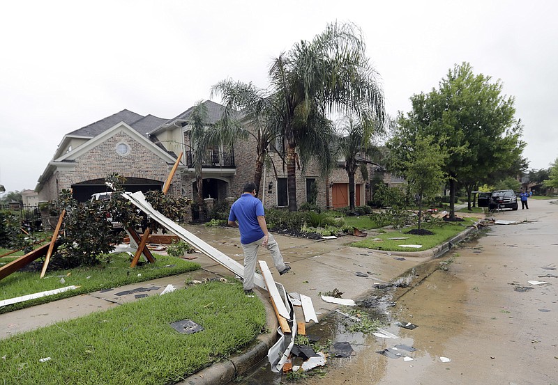 A contractor walks over debris from Hurricane Harvey Saturday, Aug. 26, 2017, in Missouri City, Texas. Harvey rolled over the Texas Gulf Coast on Saturday, smashing homes and businesses and lashing the shore with wind and rain so intense that drivers were forced off the road because they could not see in front of them. (AP Photo/David J. Phillip)