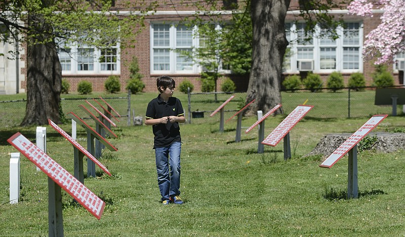 A student walks among the historical markers at the Chattanooga Confederate Cemetery, located between the campuses of the University of Tennessee at Chattanooga and the Chattanooga School for the Arts and Sciences (at rear).