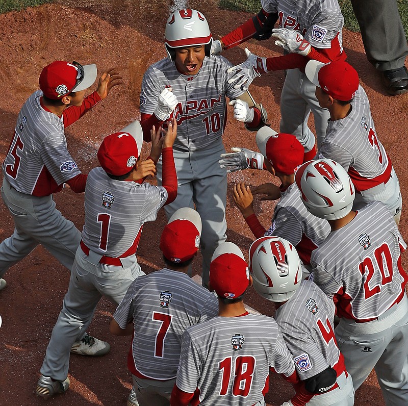 
              Japan's Keitaro Miyahara (10) is greeted by teammates after hitting a solo home run off Lufkin, Texas' Chip Buchanan in the fourth inning of the Little League World Series Championship baseball game in South Williamsport, Pa., Sunday, Aug. 27, 2017. Japan won 12-2. (AP Photo/Gene J. Puskar)
            