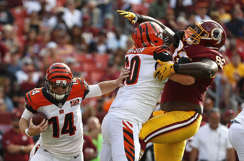 
              Cincinnati Bengals quarterback Andy Dalton (14) rushes the ball as Cincinnati Bengals center T.J. Johnson holds back Washington Redskins defensive tackle Stacy McGee in the first half of a preseason NFL football game, Sunday, Aug. 27, 2017, in Landover, Md. (AP Photo/Alex Brandon)
            