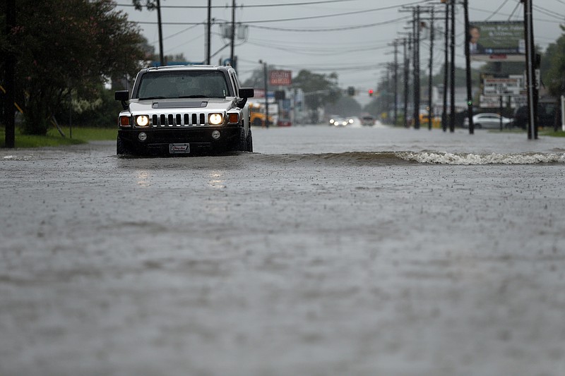 
              Cars drive through flooded streets in Lake Charles, La., as the city is receiving heavy rains from Tropical Storm Harvey, Sunday, Aug. 27, 2017. The storm came ashore on the Texas Gulf Coast as a category four hurricane. (AP Photo/Gerald Herbert)
            