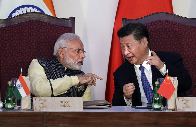 
              In this Oct. 16, 2016, file photo, Indian Prime Minister Narendra Modi, left, talks with Chinese President Xi Jinping at the BRICS summit in Goa, India. India and China have agreed to pull back their troops from a face-off in the high Himalayas where China, India and Bhutan meet, signaling a thaw in the monthslong standoff, India's government said Monday, Aug. 28, 2017. (AP Photo/Manish Swarup, File)
            