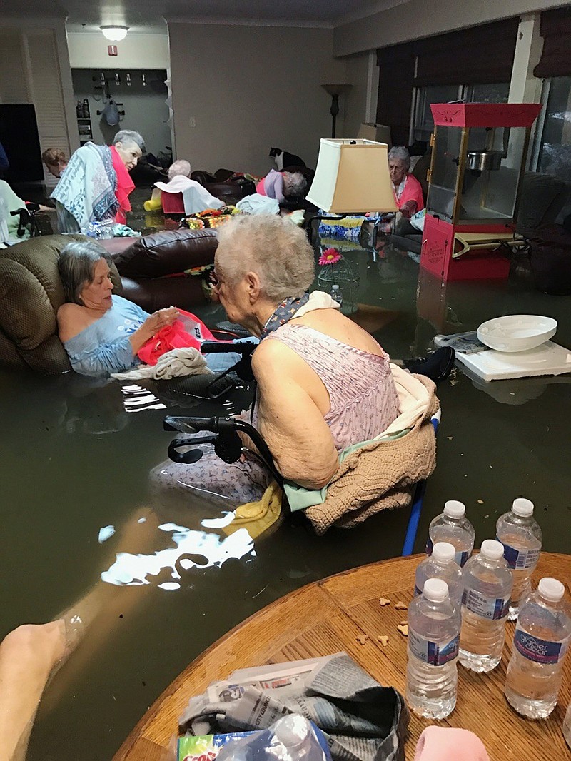 
              In this Sunday, Aug. 27, 2017, photo provided by Trudy Lampson, residents of the La Vita Bella nursing home in Dickinson, Texas, sit in waist-deep flood waters caused by Hurricane Harvey. Authorities said all the residents were safely evacuated from the facility. (Trudy Lampson via AP)
            