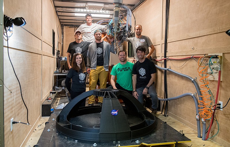 Members of the winning team of Foster + Partners and Branch Technology stand before structural components they constructed. The team won first place in a phase of a NASA competition to build a 3-D printed habitat for deep space exploration.