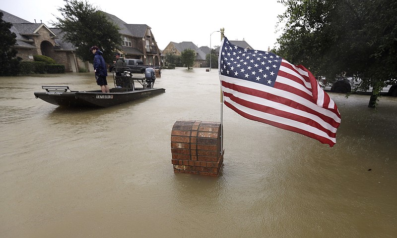 Volunteers use their boat to help evacuate residents as floodwaters from Tropical Storm Harvey rise Monday, Aug. 28, 2017, in Spring, Texas. (AP Photo/David J. Phillip)