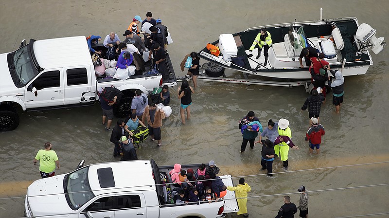 
              Evacuees are helped as floodwaters from Tropical Storm Harvey rise Tuesday, Aug. 29, 2017, in Houston. (AP Photo/David J. Phillip)
            