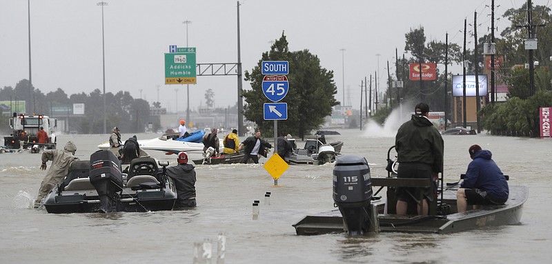 Volunteer rescue boats make their way into a flooded subdivision to rescue stranded residents as floodwaters from Tropical Storm Harvey rise Monday, Aug. 28, 2017, in Spring, Texas. (AP Photo/David J. Phillip)