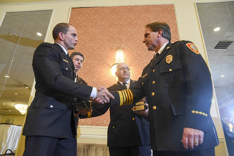 Fire Chief Chris Adams, right, congratulates Firefighter of the Year Preston Binegar, left, as Mayor Andy Berke stands near, second from left. Chattanooga Fire Department Fire Officer of the Year Captain David Tallent, stands beside Chief Adams at the annual awards dinner on Feb. 6, 2017, at the Chattanooga Choo Choo.