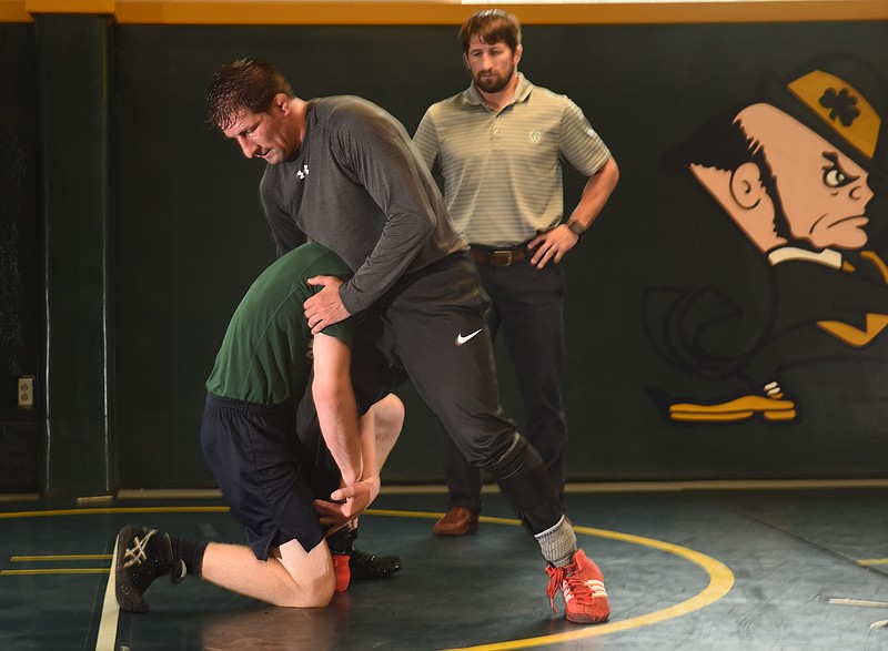Phillip Mansueto, back right, and his brother, Rocco Mansueto, , center, work with senior state placer Grant Speer in the wrestling practice facility at Notre Dame on Wednesday. Phillip has recently joined his brother on staff as part of the Irish wrestling squad.