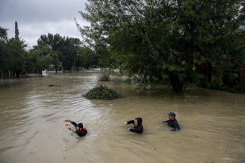 
              People wade through chest deep water down Pine Cliff Drive as Addicks Reservoir nears capacity due to near constant rain from Tropical Storm Harvey, Tuesday, Aug. 29, 2017 in Houston. (Michael Ciaglo/Houston Chronicle via AP)
            