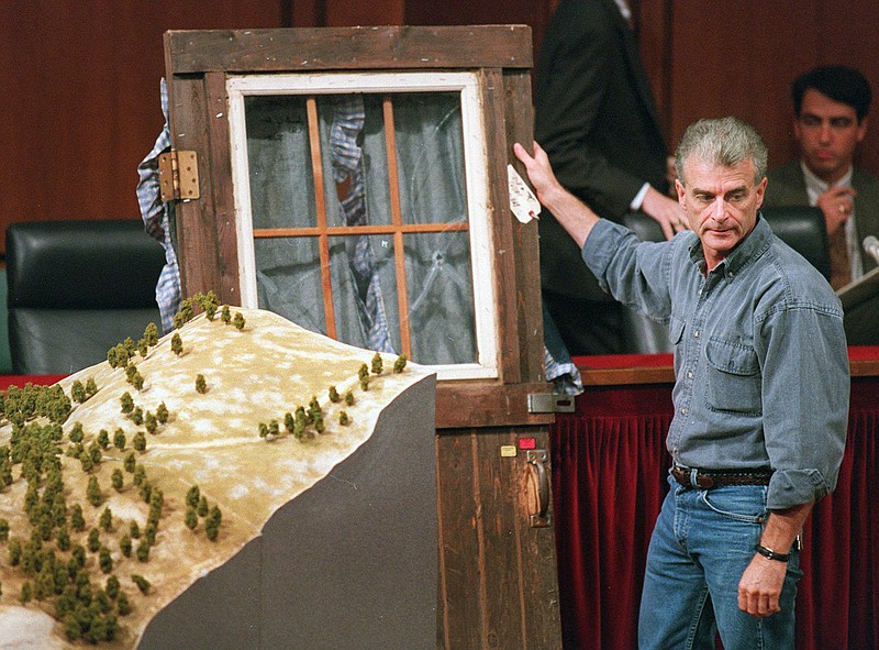 FILE - In this Sept. 6, 1995, file photo, Randy Weaver holds the door of his cabin showing holes from bullets fired during the 1992 siege of his Ruby Ridge, Idaho, home, model at left, during testimony before the Senate Judiciary Subcommittee on Capitol Hill in Washington. It's been a quarter century since a standoff in the remote mountains of northern Idaho left a 14-year-old boy, his mother and a federal agent dead and sparked the expansion of radical right-wing groups across the country that continues to this day. (AP Photo/File, Joe Marquette, File)