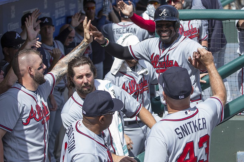 Atlanta Braves' Brandon Phillips, top right, celebrates scoring with teammates on a home run by Freddie Freeman during the first inning of the first baseball game of a doubleheader against the Philadelphia Phillies, Wednesday, Aug. 30, 2017, in Philadelphia. (AP Photo/Chris Szagola)