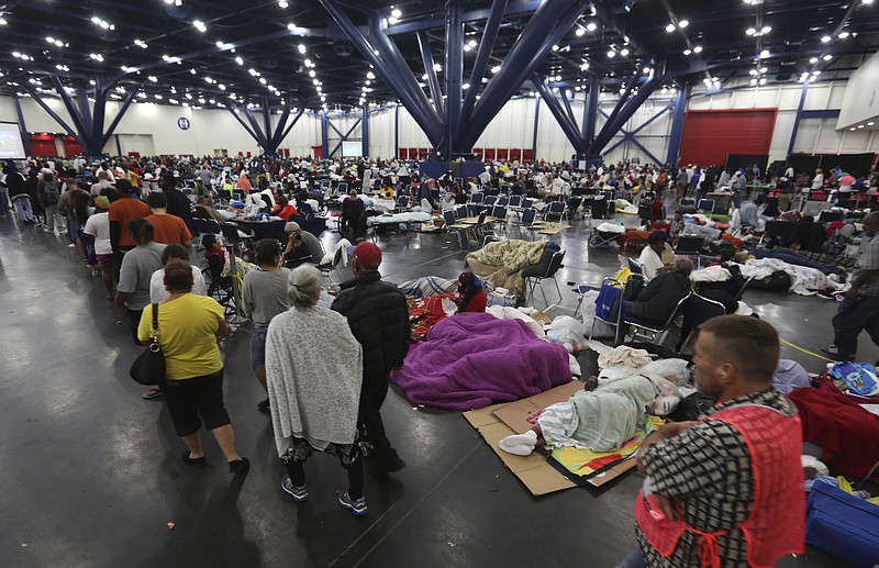 
              People line up for food as others rest at the George R. Brown Convention Center that has been set up as a shelter for evacuees escaping the floodwaters from Tropical Storm Harvey in Houston, Texas, Tuesday, Aug. 29, 2017. (AP Photo/LM Otero)
            