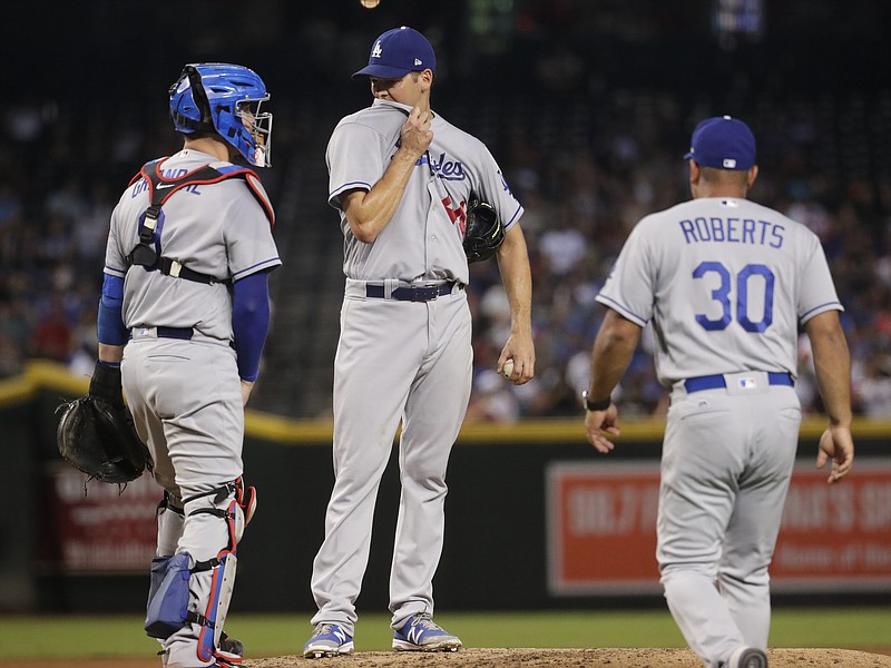 
              Los Angeles Dodgers starting pitcher Rich Hill is pulled from the game by manager Dave Roberts (30) as catcher Yasmani Grandal stands on the mound, during the fourth inning of the Dodgers' baseball game against the Arizona Diamondbacks, Tuesday, Aug. 29, 2017, in Phoenix. (AP Photo/Matt York)
            