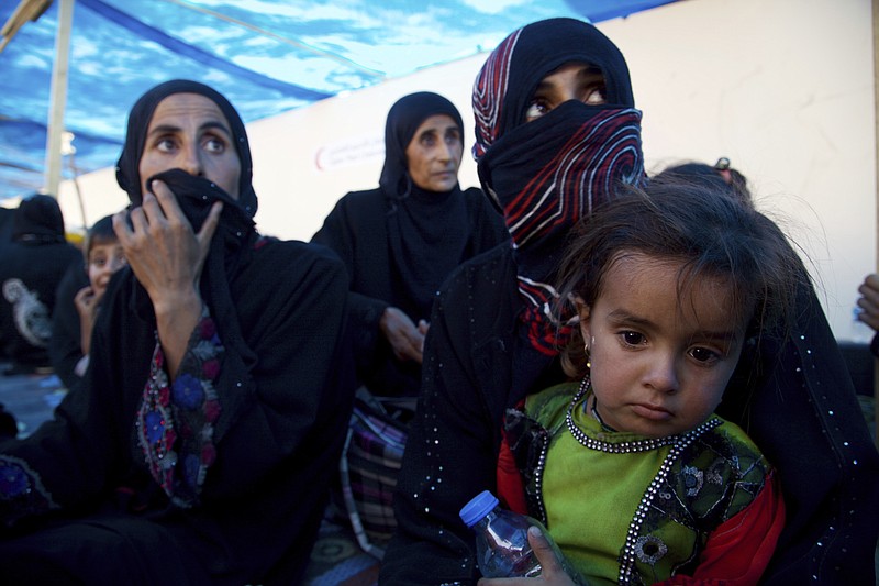 
              FILE - In this Saturday, Aug. 26, 2017 file photo, displaced Iraqi women and children sit on the ground at a collection point west of Mosul on the outskirts of Tal Afar, Iraq. Iraq's prime minister declared the town of Tal Afar "fully liberated" from the Islamic State group after a nearly two-week operation. Haider al-Abadi said Thursday, Aug. 31, 2017, that Iraqi troops "eliminated and smashed Daesh terrorists" in al-Ayadia district, about 10 kilometers (6 miles) northwest of Tal Afar, where the militants fled last week. Daesh is the Arabic acronym for IS. (AP Photo/Balint Szlanko, File)
            