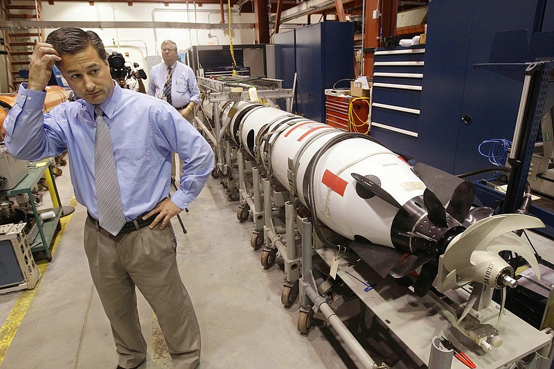 
              FILE - In this Tuesday, July 31, 2012 file photo, Christopher Del Mastro, head of anti submarine warfare mobil targets stands next to an unmanned underwater vehicle (UUV) in a lab at the Naval Undersea War Center in Middletown, RI. President Donald Trump and U.S. Navy leaders have said that the nation needs about 350 ships, roughly 75 more ships than the fleet has today. Adm. John Richardson, chief of naval operations, said they could get closer to the Navy's goal by counting unmanned vehicles that have capabilities similar to a manned ship. (AP Photo/Stephan Savoia, File)
            