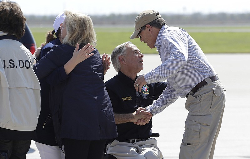 
              Texas Gov. Greg Abbott, center, greets Energy Secretary Rick Perry, right, as they prepare to visit areas affected by Hurricane Harvey, Thursday, Aug. 31, 2017, in Corpus Christi, Texas. (AP Photo/Eric Gay)
            