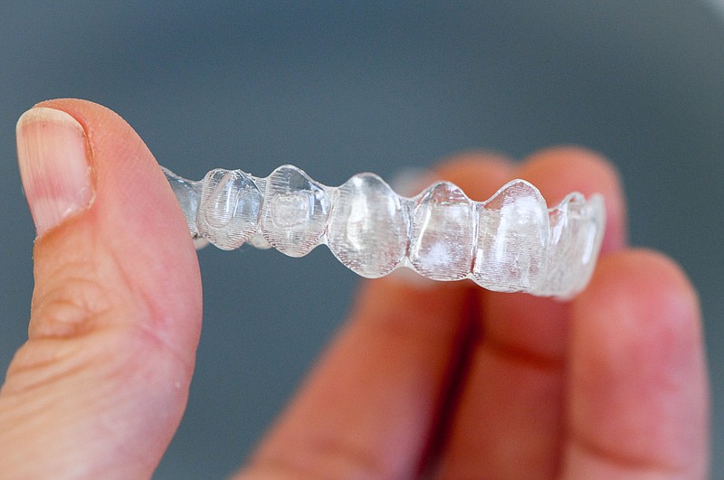 Invisalign custom-made clear aligners fit snugly over the teeth.