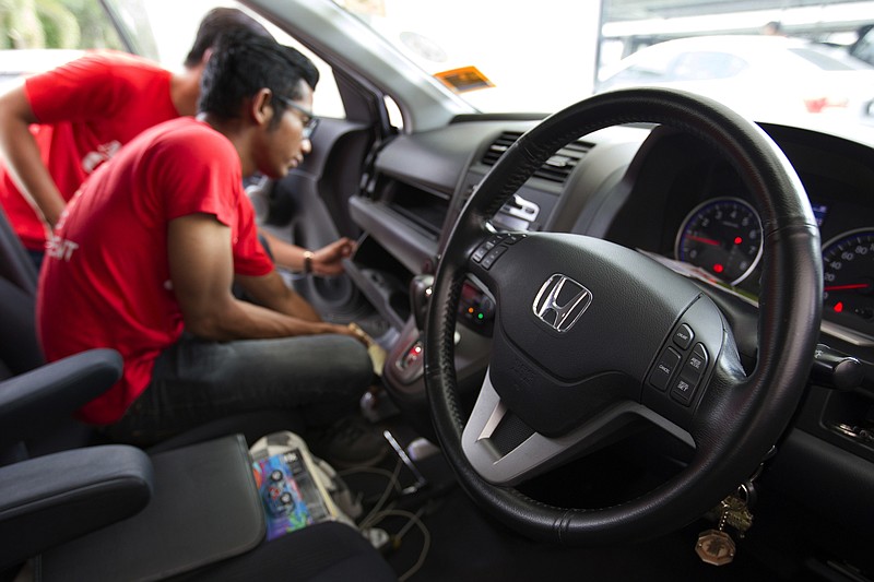 
              FILE - In this Sunday, Nov. 20, 2016, file photo, a Honda technician works on an airbag during a free airbag replacement event in Kuala Lumpur, Malaysia. Honda and some of the people suing the company over faulty Takata air bag inflators have agreed to a $605 million settlement. It covers owners of 16.5 million Honda vehicles. Honda gets credit for $121 million it spent on rental cars for customers who had to wait for parts. That leaves $484 million to reimburse owners for expenses, attorney fees and administrative costs. (AP Photo/Lim Huey Teng, File)
            