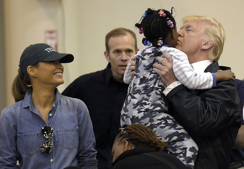 President Donald Trump and Melania Trump meet people impacted by Hurricane Harvey during a visit to the NRG Center in Houston, Saturday, Sept. 2, 2017. He lifted this girl into his arms to give her a kiss. It was his second trip to Texas in a week, and this time his first order of business was to meet with those affected by the record-setting rainfall and flooding. He's also set to survey some of the damage and head to Lake Charles, Louisiana, another hard-hit area. (AP Photo/Susan Walsh)