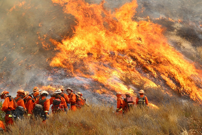 A crew with California Department of Forestry and Fire Protection (Cal Fire) battles "La Tuna" brushfire on the hillside in Burbank, Calif., Saturday, Sept. 2, 2017. Several hundred firefighters worked to contain a blaze that chewed through brush-covered mountains, prompting evacuation orders for homes in Los Angeles, Burbank and Glendale. (Matt Hartman via AP)