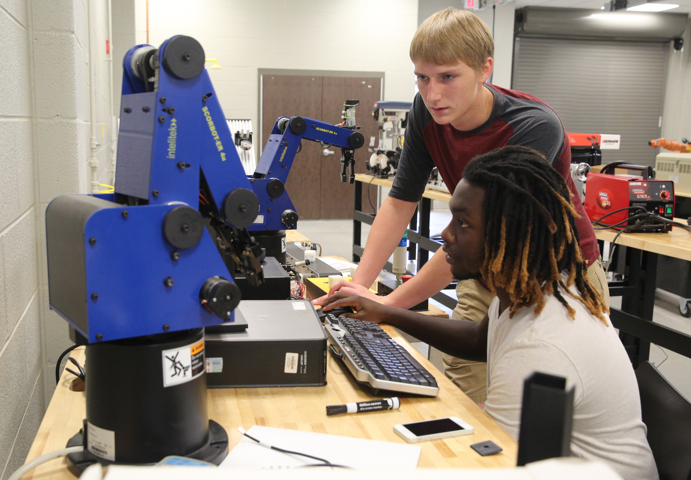 Tully Holden, 17, and Martavius Harris, 18, program a robot to play checkers Friday, Sept. 1, 2017, in class at the Gordon County College and Career Academy in Calhoun, Ga. The two will be participating in a competition together later this year with the robot.