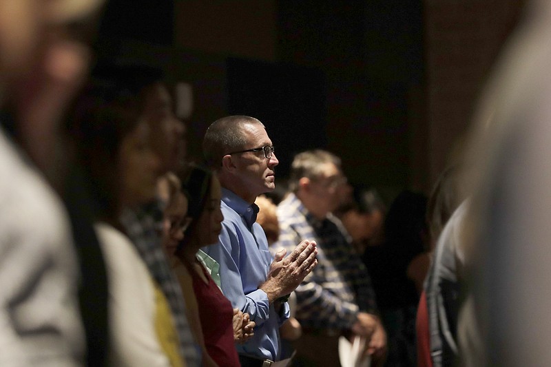 
              A man prays as he attends services for parishioners from flood-damaged St Ignatius Loyola Catholic Community Church in the auditorium of Klein High School Sunday, Sept. 3, 2017, in Klein, Texas. As clean up and repairs continue at the church just outside of Houston, parishioners turned this high school auditorium into their sanctuary on a Sunday that was declared National Day of Prayer for Harvey victims by President Donald Trump. (AP Photo/Gregory Bull)
            