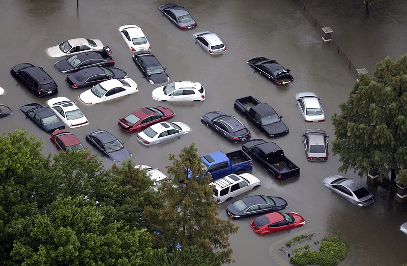 This Tuesday, Aug. 29, 2017, photo shows flooded cars near the Addicks Reservoir as floodwaters from Harvey rise in Houston. Auto industry experts estimate that 500,000 to 1 million cars, trucks and SUVs were damaged by floodwaters from Hurricane Harvey. Most will have so much water damage that they can't be fixed, and insurance companies will declare them total losses. Yet the damaged cars could be retitled and sold to unsuspecting buyers nationwide. Experts warn against buying the cars because damage could be hidden for years before causing problems. (AP Photo/David J. Phillip, File)
            