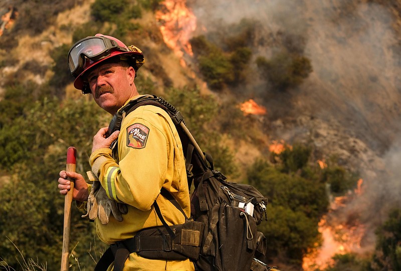 
              A crew member with California Department of Forestry and Fire Protection (Cal Fire) battles a brushfire on the hillside in Burbank, Calif., Saturday, Sept. 2, 2017.  Several hundred firefighters worked to contain a blaze that chewed through brush-covered mountains, prompting evacuation orders for more than 600 homes in Los Angeles, Burbank and Glendale. (AP Photo/Ringo H.W. Chiu)
            