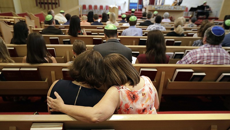 
              Debbie Uzick, right, puts her arm around Natalie Hausman-Weiss during a Bar Mitzvah on Saturday, Sept. 2, 2017, in Houston. Both of their homes were flooded in the aftermath of Harvey. (AP Photo/David J. Phillip)
            