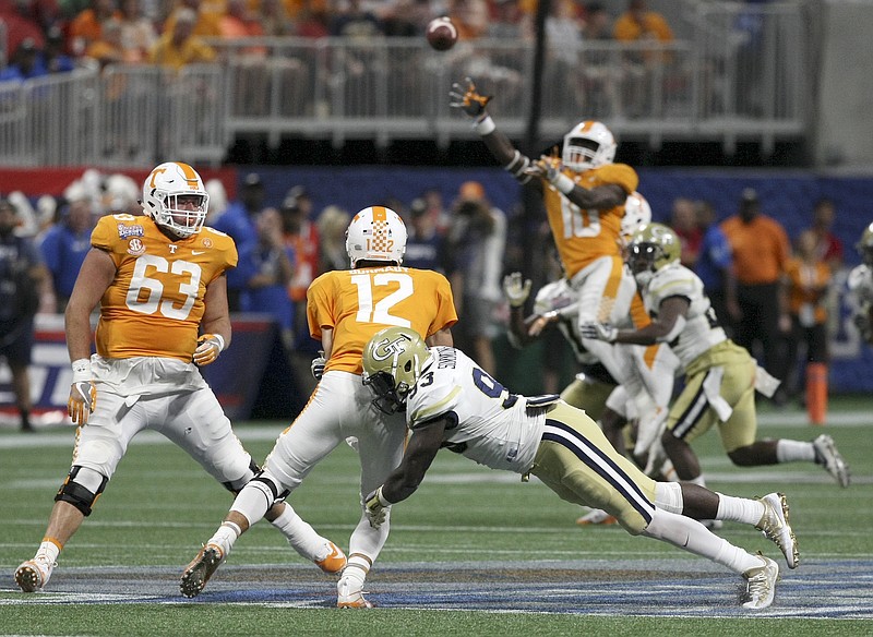 Tennessee quarterback Quinten Dormady (12) throws under pressure from Georgia Tech defensive lineman Antonio Simmons (93) during the Chick-fil-A Kickoff Game at Mercedes-Benz Stadium on Monday, Sept. 4, in Atlanta, Ga.