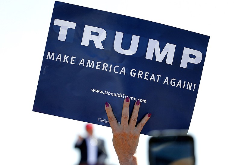 
              FILE - In this March 19, 2016, file photo, a supporter holds a sign as then Republican presidential candidate Donald Trump speaks during a campaign rally in Fountain Hills, Ariz. A Georgia school district apologized for an Aug. 31, 2017, incident in which a teacher told two students that their "Make America Great Again" shirts weren’t allowed in class. (AP Photo/Matt York, File)
            