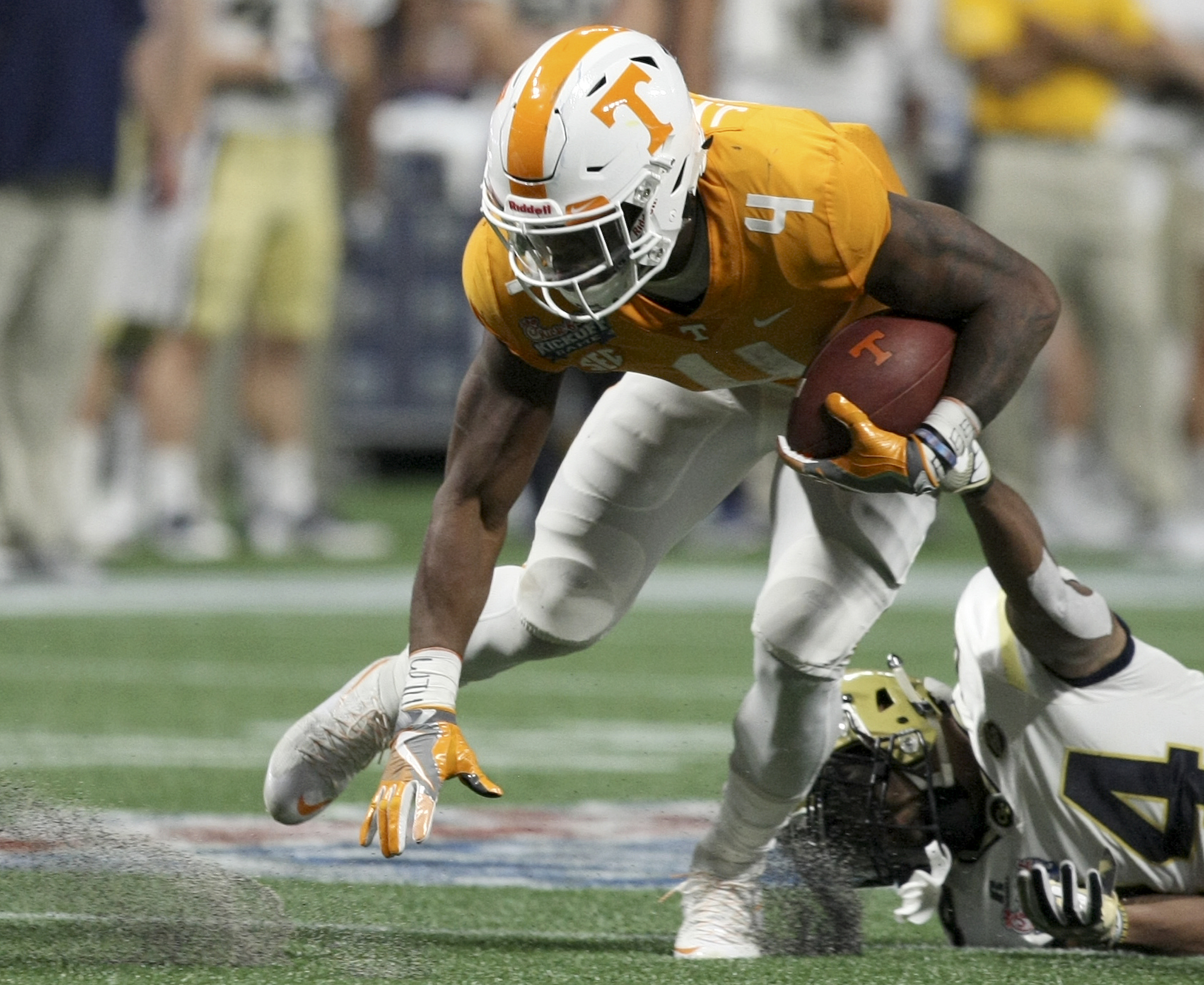 Georgia Tech defensive back Corey Griffin (14) tries to bring down Tennessee running back John Kelly (4) during the Chick-fil-A Kickoff Game at Mercedes-Benz Stadium on Monday, Sept. 4, in Atlanta, Ga.