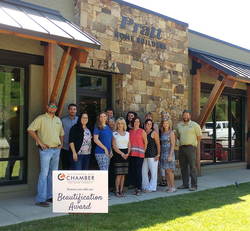 Sonja Millard and Cathy Schein pose with the staff of Pratt Home Builders, winner of the Red Bank Beautification Award given by the city's Chamber of Commerce.