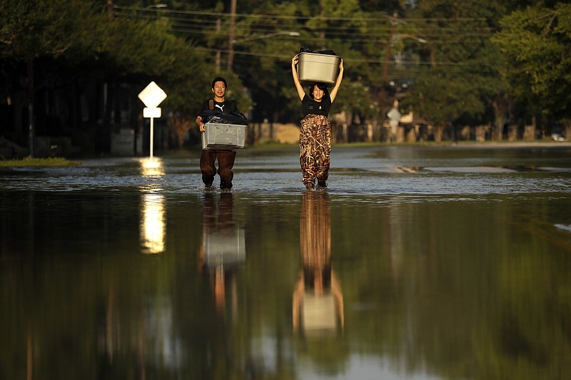 
              Mariko Shimmi, right, helps carry items out of the home of Ken Tani in a neighborhood still flooded from Harvey on Monday, Sept. 4, 2017, in Houston. Some neighborhoods around Houston remain flooded and thousands of people have been displaced by torrential rains and catastrophic flooding since Harvey slammed into Southeast Texas last week. (AP Photo/Gregory Bull)
            