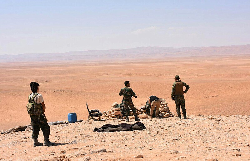 
              This photo released on Saturday, Sept 2, 2017, by the Syrian official news agency SANA, shows Syrian troops and pro-government gunmen standing guard at one of the frontline hills where they are fighting Islamic State militants in the eastern city of Deir el-Zour, Syria. Syrian opposition activists and state media say government forces are close to breaking a nearly three-year siege imposed by the Islamic State group on parts of the provincial capital of the oil-rich province of the same name. (SANA via AP)
            