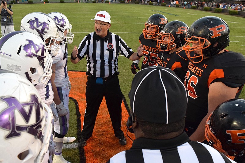 The referee instructs the captains before the coin toss.  The Marion County Warriors visited the South Pittsburg Pirates in TSSAA football action on September 2, 2016. 