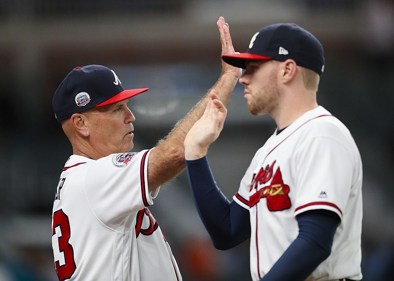 Atlanta Braves manager Brian Snitker, left, celebrates with Freddie Freeman at the conclusion of the second game of a baseball doubleheader against the Texas Rangers, Wednesday, Sept. 6, 2017, in Atlanta. The Braves won 5-4. (AP Photo/Todd Kirkland)