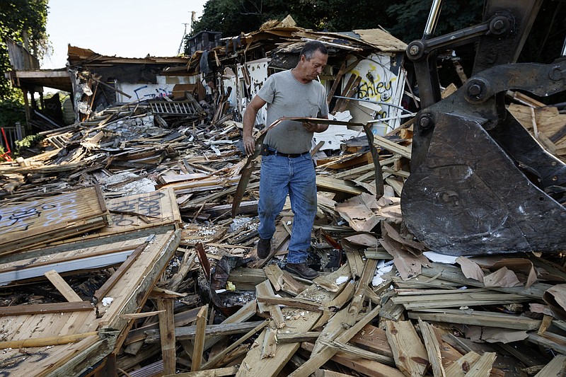 Terry Bishop removes copper from the Missionary Ridge mansion built in 1972 by strip club mogul Billy Hull during its demolition on Friday, Sept. 8, 2017, in Chattanooga, Tenn. The mansion, which included a helipad and a Playboy bunny-themed swimming pool, had long been considered a nuisance by Missionary Ridge residents. It was left abandoned only a year after construction when Hull was jailed for hiring a hitman to kill his wife's lover.