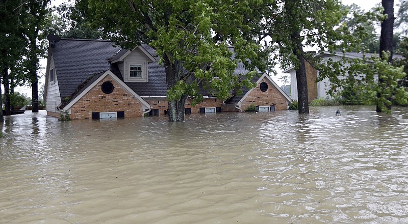 A home is surrounded by floodwaters from Tropical Storm Harvey on Monday, Aug. 28, 2017, in Spring, Texas. Homeowners suffering from Harvey flood damage are more likely to be on the hook for losses than victims of prior storms, a potentially crushing blow to personal finances and neighborhoods along the Gulf Coast. Experts say far too few homeowners have flood insurance, just two of ten living in Harvey’s path of destruction. (AP Photo/David J. Phillip)