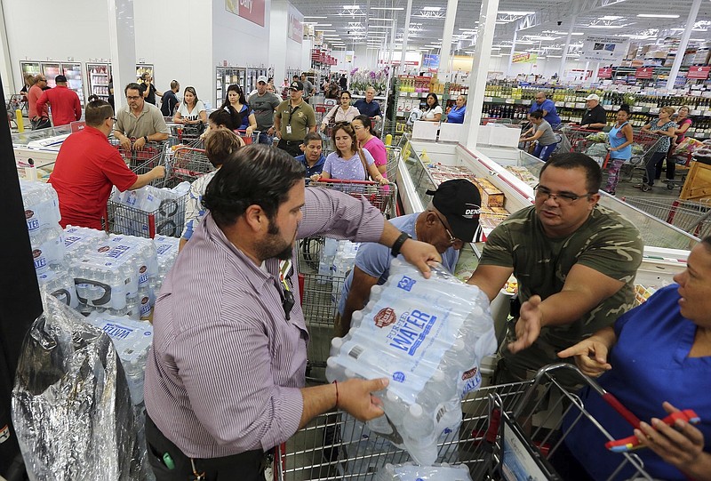 
              FILE- This Sept. 5, 2017 file photo shows residents in a long line waiting to purchase water at BJ Wholesale in preparation for Hurricane Irma in Miami. With images of Hurricane Harvey's wrath in Texas still fresh and 25-year-old memories of Hurricane Andrew's destruction, warnings that Hurricane Irma might be the long-dreaded "big one" has brought many Floridians close to panic. Lines for gas, food and supplies stretched outside businesses as the South Florida region of more than 6 million people rushed to prepare for Irma, which forecasters say could strike over the weekend as a Category 4 or 5 storm. (Roberto Koltun/Miami Herald via AP, File)
            