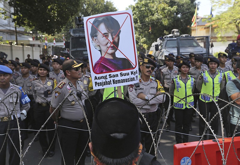 
              A Muslim man displays a defaced poster of Myanmar's State Counsellor Aung San Suu Kyi during a rally against the persecution of Rohingya Muslims outside Myanmar Embassy in Jakarta, Indonesia, Friday, Sept. 8, 2017. Dozens of Muslims staged the rally condemning violence in Myanmar against its Rohingya minority. Writings on the poster read: "Perpetrator of crimes against humanity." (AP Photo/Tatan Syuflana)
            